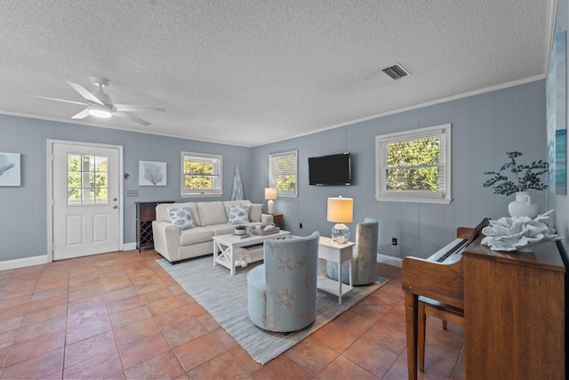 living area with a wealth of natural light, visible vents, crown molding, and light tile patterned flooring