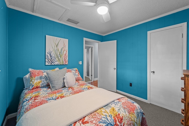 carpeted bedroom with attic access, visible vents, ornamental molding, and a textured ceiling