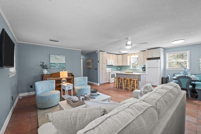 living area with crown molding, visible vents, light tile patterned flooring, a textured ceiling, and baseboards