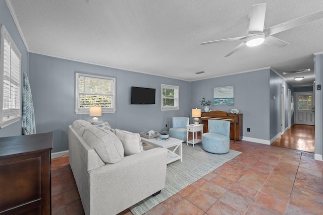 living area with baseboards, ceiling fan, ornamental molding, and a textured ceiling