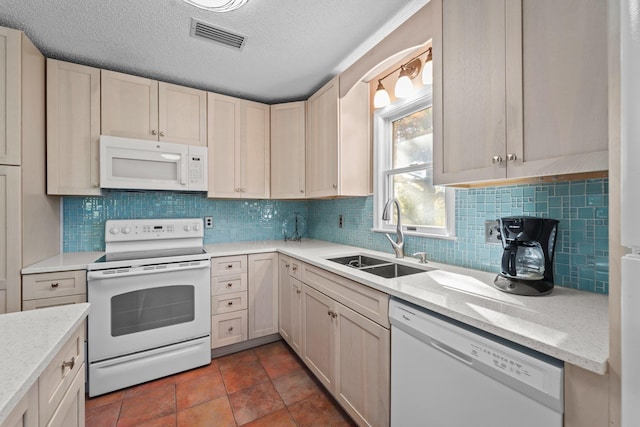 kitchen with white appliances, visible vents, a sink, and backsplash