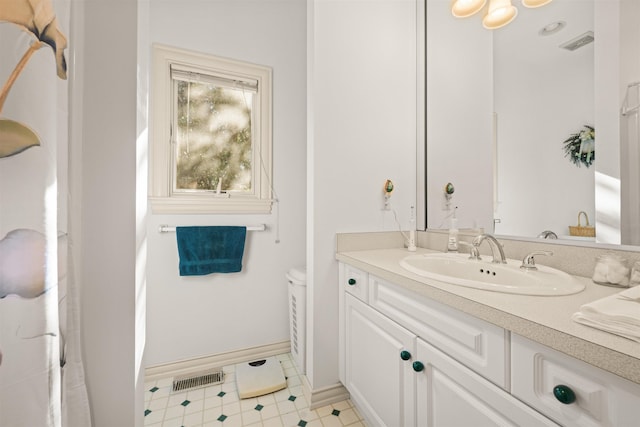 bathroom with toilet, baseboards, visible vents, and vanity