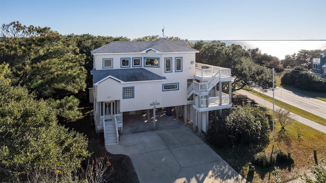 view of front of home with driveway, a balcony, stairway, and a carport