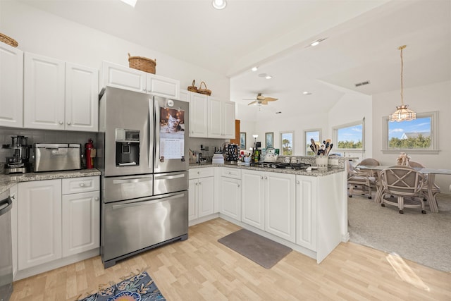 kitchen featuring lofted ceiling, stainless steel appliances, a peninsula, visible vents, and white cabinetry