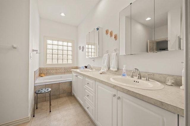 bathroom featuring double vanity, tiled tub, a sink, and tile patterned floors