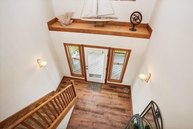 entryway featuring stairway, baseboards, visible vents, and wood finished floors