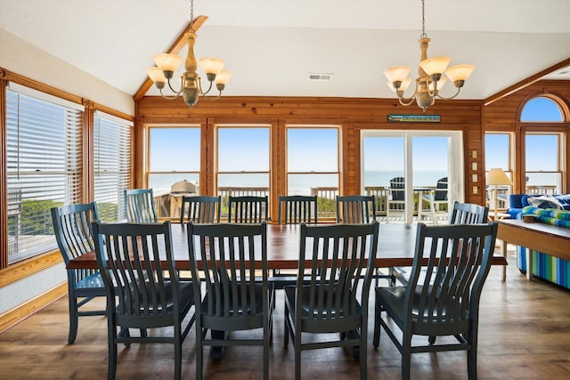 dining room featuring vaulted ceiling, visible vents, a water view, and an inviting chandelier