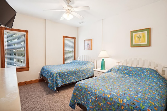 carpeted bedroom featuring ceiling fan, visible vents, and baseboards