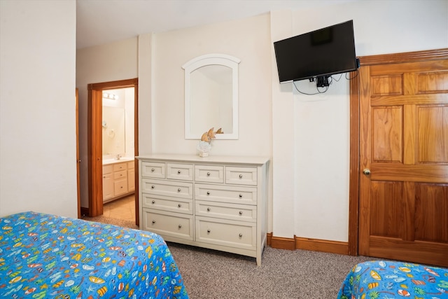 bedroom featuring light carpet, ensuite bath, and baseboards