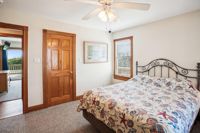 carpeted bedroom with access to outside, multiple windows, ceiling fan, and baseboards