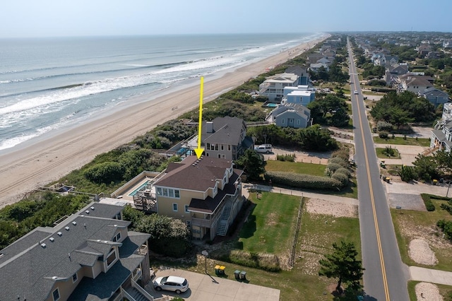 birds eye view of property featuring a water view, a residential view, and a beach view