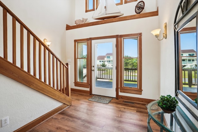 foyer entrance featuring stairway, dark wood-style flooring, visible vents, and a healthy amount of sunlight