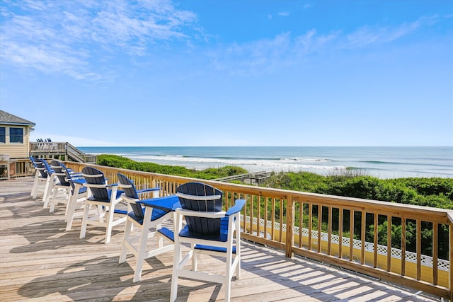 wooden deck with a water view and a view of the beach