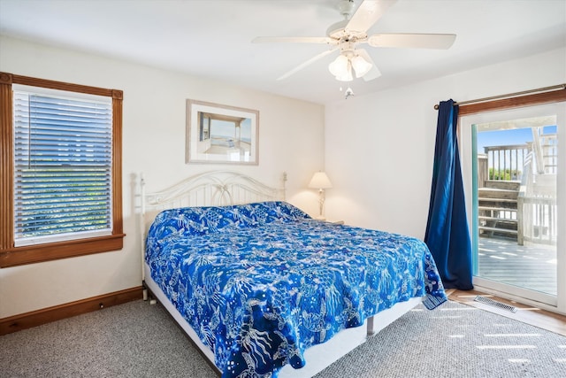 carpeted bedroom with baseboards, multiple windows, visible vents, and ceiling fan