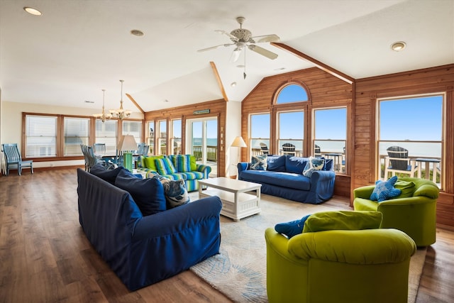 living room with lofted ceiling, dark wood-style floors, and ceiling fan with notable chandelier