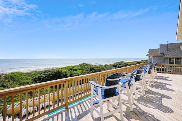 wooden deck with a beach view, a water view, and a pool