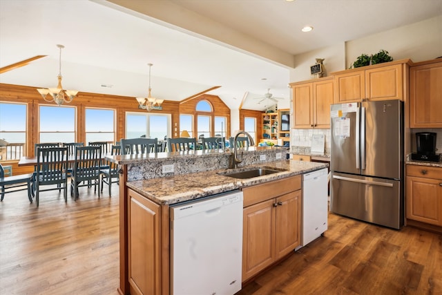 kitchen with dishwasher, an island with sink, a sink, and freestanding refrigerator