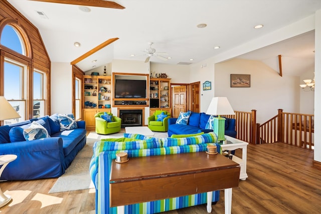 living room featuring recessed lighting, a fireplace, wood finished floors, vaulted ceiling, and an inviting chandelier