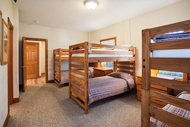 bedroom with baseboards and light colored carpet