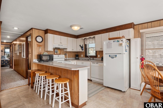 57105 Lighthouse Rd Lot 2, Hatteras, NC 27943 - kitchen featuring white appliances, a sink, under cabinet range hood, white cabinets, and wood walls