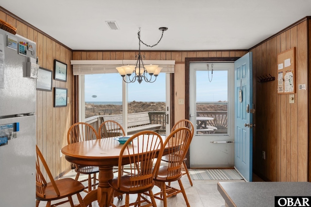 57105 Lighthouse Rd Lot 2, Hatteras, NC 27943 - dining area with wood walls, healthy amount of natural light, a chandelier, and baseboards