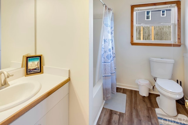 full bathroom featuring toilet, wood finished floors, vanity, baseboards, and shower / bathtub combination with curtain