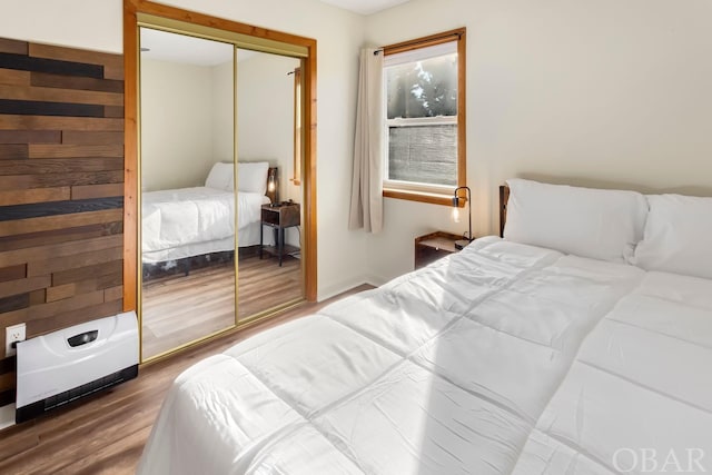 bedroom with dark wood-style floors and a closet