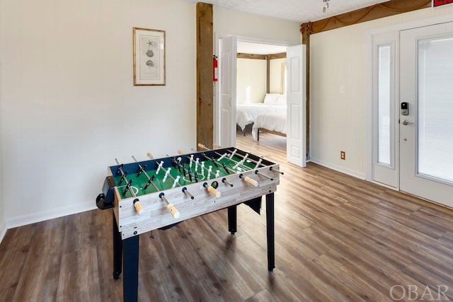 playroom featuring baseboards and wood finished floors