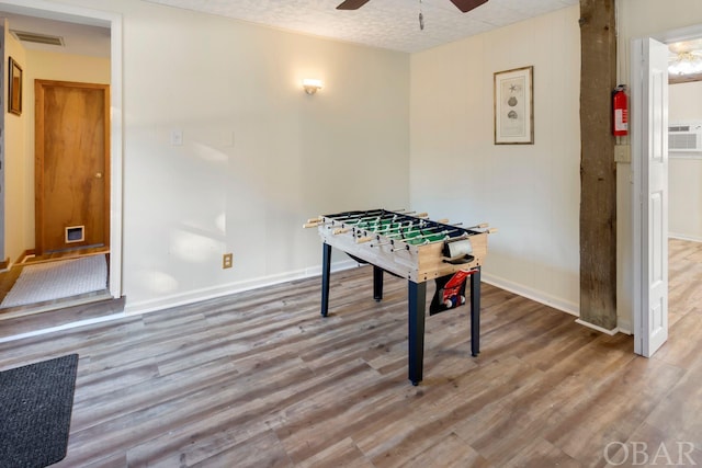 rec room featuring ceiling fan, light wood-type flooring, visible vents, and baseboards