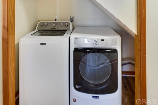 laundry area featuring laundry area, washing machine and clothes dryer, and wood finished floors