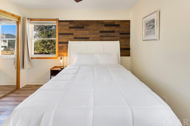 bedroom with baseboards and wood finished floors