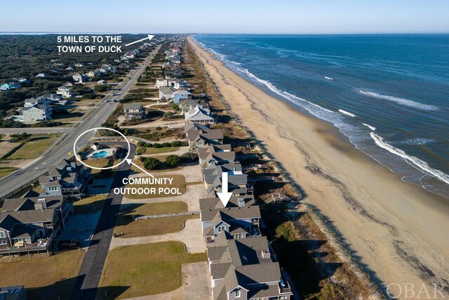 drone / aerial view with a view of the beach, a water view, and a residential view