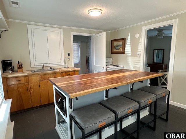 kitchen with ornamental molding, a sink, dark wood finished floors, white electric range oven, and butcher block counters