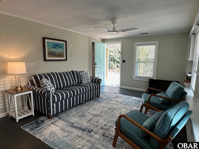 living area featuring a ceiling fan, wood finished floors, visible vents, a textured ceiling, and crown molding