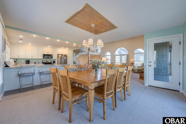 dining area with a notable chandelier, recessed lighting, and light carpet