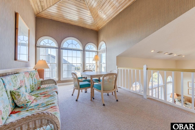 interior space featuring carpet flooring, wood ceiling, and high vaulted ceiling