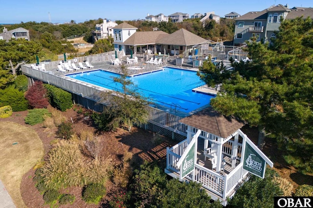 community pool featuring a residential view, a patio, and fence