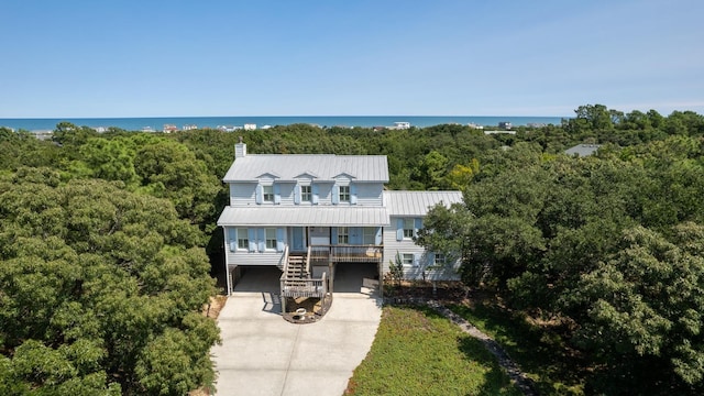 birds eye view of property featuring a water view and a wooded view