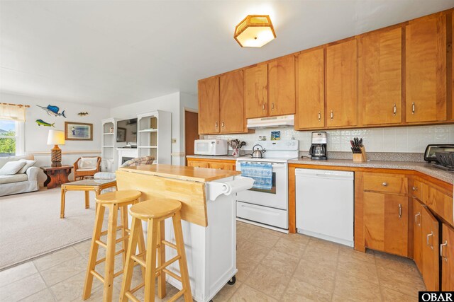 2201 Sandpiper Rd Lot # 13, Corolla, NC 27927 - kitchen featuring white appliances, under cabinet range hood, open floor plan, tasteful backsplash, and a breakfast bar area