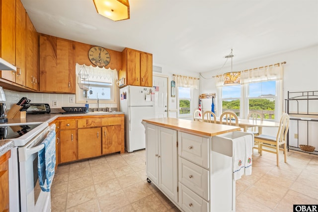 2201 Sandpiper Rd Lot # 13, Corolla, NC 27927 - kitchen with white appliances, brown cabinetry, decorative backsplash, and a kitchen island