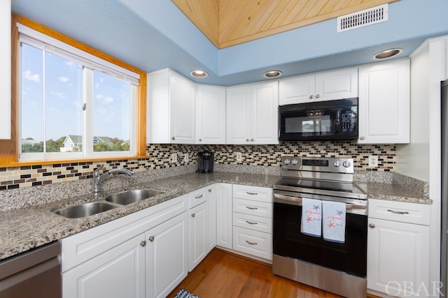 kitchen featuring stainless steel appliances, a sink, visible vents, white cabinetry, and light stone countertops