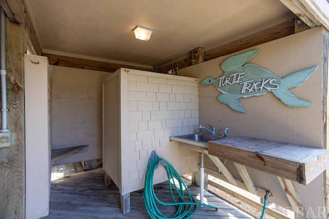 exterior space featuring tile counters, a sink, and wood finished floors