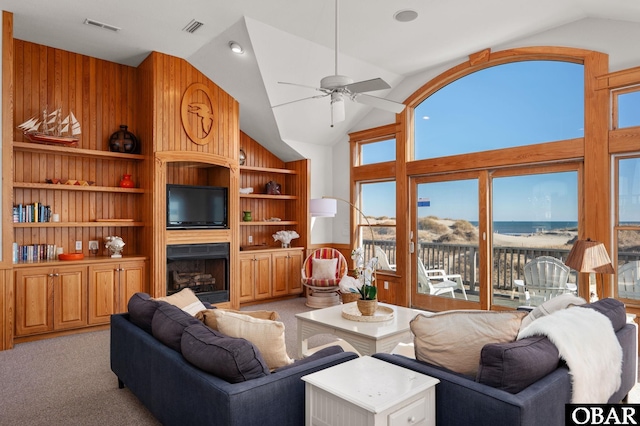 living room featuring light carpet, built in shelves, a fireplace, and visible vents