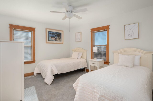 carpeted bedroom with a ceiling fan and baseboards