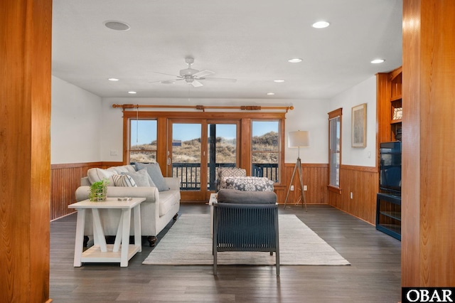 living room featuring recessed lighting, a wainscoted wall, dark wood finished floors, and wood walls