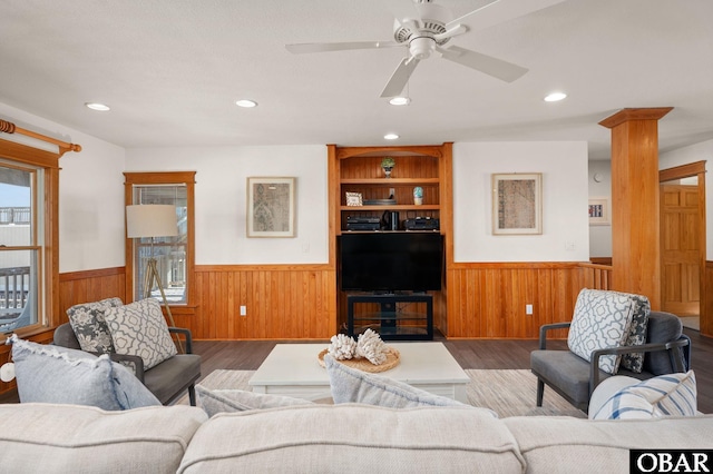 living area with wainscoting, wood finished floors, and wooden walls