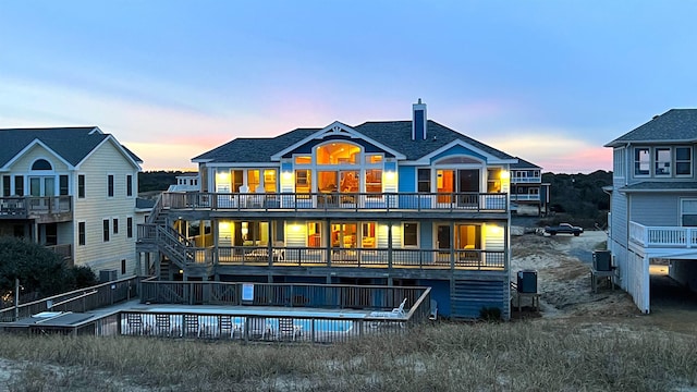 back of house with stairs, a deck, roof with shingles, and cooling unit