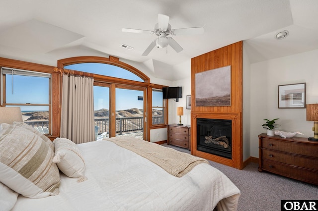 carpeted bedroom featuring a fireplace, visible vents, access to exterior, vaulted ceiling, and multiple windows