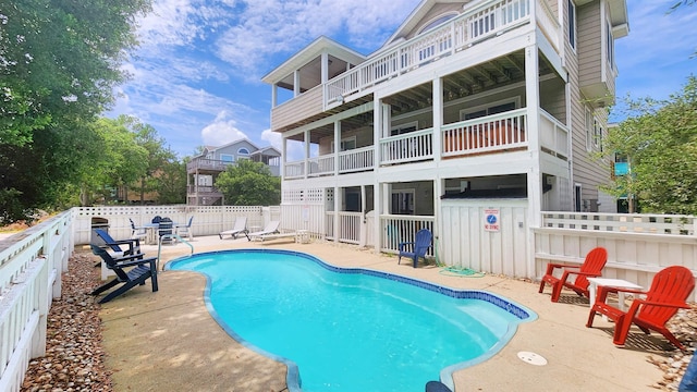 back of property with a patio, a fenced backyard, and a fenced in pool