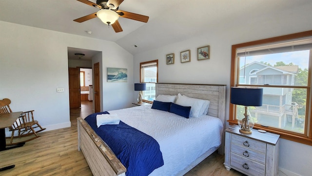 bedroom featuring light wood-type flooring, baseboards, a ceiling fan, and lofted ceiling